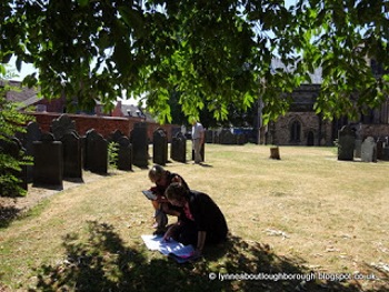 Visitors research the tombstones